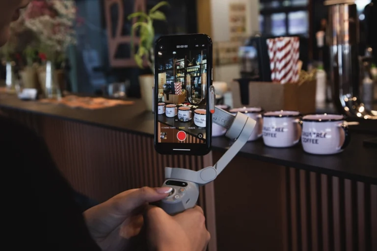 In the central part of the photo you can see a phone in a gimbal, recording a restaurant counter with pink enamel mugs.
